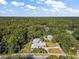 An aerial view of a gray single Gathering home surrounded by lush trees and blue sky at 1661 Votaw Rd, Apopka, FL 32703