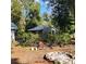 View of the backyard featuring a fire pit, ample greenery, and the exterior of the property at 1661 Votaw Rd, Apopka, FL 32703
