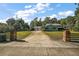 Long paved driveway leading to a single-Gathering home with a lush lawn and tree lined back drop at 1661 Votaw Rd, Apopka, FL 32703