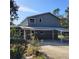 Gray home exterior showcasing a covered parking area and low-maintenance landscaping at 1661 Votaw Rd, Apopka, FL 32703