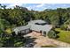 An aerial view of a single-Gathering home with a gray roof, well-manicured lawn, and mature trees at 1661 Votaw Rd, Apopka, FL 32703