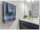 Stylish half bath with marble countertop, blue vanity, and elegant fixtures at 19318 Banfield Pl, Orlando, FL 32827