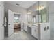 Elegant bathroom featuring dual vanities, white cabinets, and gold fixtures at 19318 Banfield Pl, Orlando, FL 32827