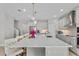 Kitchen island with quartz countertop, seating, stainless steel appliances, and stylish pendant lighting at 19318 Banfield Pl, Orlando, FL 32827