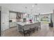Open kitchen featuring an island with seating, stainless steel appliances, and a view into the living room at 19318 Banfield Pl, Orlando, FL 32827