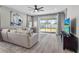 Well-lit living room showcasing a comfortable sofa, entertainment center, and sliding glass doors leading to the outside at 19318 Banfield Pl, Orlando, FL 32827