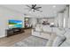 Open-concept living room with a TV, comfortable seating, and a view of the dining room and kitchen at 19318 Banfield Pl, Orlando, FL 32827