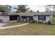 Charming single-story home with a well-manicured lawn, decorative shutters, and a welcoming front porch at 1938 Eastbrook Blvd, Winter Park, FL 32792