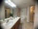 Well-lit bathroom with dual sinks, soaking tub, and glass shower at 1956 Myakka Ct, Poinciana, FL 34759