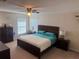 Well-lit primary bedroom featuring dark furniture and a neutral color scheme at 1956 Myakka Ct, Poinciana, FL 34759