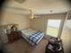 Carpeted bedroom featuring ceiling fan, bed, and sitting area with view at 1956 Myakka Ct, Poinciana, FL 34759