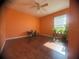 Bright bedroom with wood floor, large window with plants, and orange walls at 1956 Myakka Ct, Poinciana, FL 34759