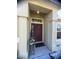 Front porch featuring a decorative front door, small window, and neat plants beside the door at 1956 Myakka Ct, Poinciana, FL 34759