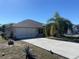 Charming single Gathering home featuring a two car garage, palm tree, and well-maintained lawn at 1956 Myakka Ct, Poinciana, FL 34759
