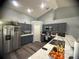 Modern kitchen featuring stainless steel appliances, ample counter space, and stylish gray cabinetry at 1956 Myakka Ct, Poinciana, FL 34759
