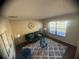 Bright living room featuring a large window, comfortable seating, stylish rug, and decorative accents at 1956 Myakka Ct, Poinciana, FL 34759