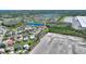 Aerial view of community homes, landscaping, pond, and large building construction in background at 2629 Maggiore Cir, Kissimmee, FL 34746