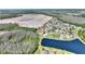 Aerial view of neighborhood home and pond, with building construction in background at 2629 Maggiore Cir, Kissimmee, FL 34746
