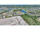 Aerial view of homes next to a pond, with a building construction in the background at 2629 Maggiore Cir, Kissimmee, FL 34746
