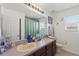 Well-lit bathroom featuring a double sink vanity, large mirror, and window for natural light at 2629 Maggiore Cir, Kissimmee, FL 34746