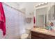 A functional bathroom with patterned shower curtain and a single sink vanity at 2629 Maggiore Cir, Kissimmee, FL 34746