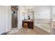 Bright bathroom featuring a single vanity, walk-in shower, and a soaking tub at 2629 Maggiore Cir, Kissimmee, FL 34746