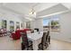 Bright dining room featuring large windows, tray ceilings, and an adjacent seating area at 2629 Maggiore Cir, Kissimmee, FL 34746