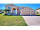 Beautiful two-story home with well-manicured lawn, brick driveway, and three-car garage at 2629 Maggiore Cir, Kissimmee, FL 34746