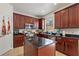 Kitchen featuring dark wood cabinets, island with dark countertop and stainless steel appliances at 2629 Maggiore Cir, Kissimmee, FL 34746