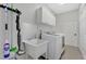 Functional laundry room with washer, dryer, utility sink, and ample storage cabinets at 2877 Ashton Ter, Oviedo, FL 32765