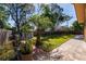 Large backyard with well-maintained lawn, privacy fence, mature trees, and paved patio area for outdoor enjoyment at 300 Radebaugh Dr, Longwood, FL 32779