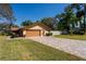 Charming home exterior with a paved driveway, well-maintained lawn, mature trees, and an attached garage at 300 Radebaugh Dr, Longwood, FL 32779