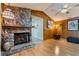 Living room featuring stone fireplace, hardwood floors, and wood paneled walls at 300 Radebaugh Dr, Longwood, FL 32779