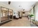 Bright sunroom features neutral tiling, ceiling fans, contemporary furniture, and sliding glass doors to the outdoor space at 300 Radebaugh Dr, Longwood, FL 32779