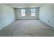 An open bedroom area with two windows offers potential for customization and ample natural light at 30108 Misty Pines Rd, Mount Dora, FL 32757