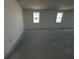 Expansive room showcases smooth concrete floors and bright natural light from two windows at 30162 Rustic Mill St, Mount Dora, FL 32757