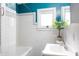 Bright bathroom featuring a classic white tile design and a teal accent wall at 311 E Wallace St, Orlando, FL 32809