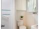 Bright bathroom featuring white tile, a shower with curtain, and a toilet with a window view at 311 E Wallace St, Orlando, FL 32809