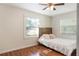 Sunlit bedroom featuring wood-look floors, a ceiling fan, and a large window with blinds at 311 E Wallace St, Orlando, FL 32809