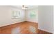 Empty bedroom with wood-look floors, white walls, a ceiling fan and two windows at 311 E Wallace St, Orlando, FL 32809