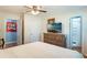 Bright bedroom with wood floors, dresser with a television, and access to the en-suite bathroom at 311 E Wallace St, Orlando, FL 32809