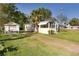 Side view of the charming home with a detached garage and a spacious yard at 311 E Wallace St, Orlando, FL 32809