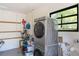 Bright laundry area with stacked washer/dryer, tool rack, and natural light from the window at 311 E Wallace St, Orlando, FL 32809
