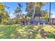 Spacious backyard with mature trees, a wooden fence, and an expansive playset for endless outdoor fun at 3420 Arnel Dr, Winter Park, FL 32792