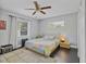 Relaxing bedroom featuring hardwood floors, a ceiling fan, a comfortable bed, and two windows at 3420 Arnel Dr, Winter Park, FL 32792