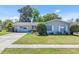 Charming home featuring a well-maintained lawn, mature landscaping and updated gray exterior paint at 3420 Arnel Dr, Winter Park, FL 32792