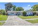 Charming home featuring a well-maintained lawn, mature landscaping and updated gray exterior paint at 3420 Arnel Dr, Winter Park, FL 32792