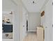 Hallway leading to the kitchen, featuring neutral walls, wood-look floors, and decorative accents at 3420 Arnel Dr, Winter Park, FL 32792