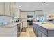 Bright modern kitchen features white cabinets, stainless steel appliances, granite counters, and wood-look flooring at 3420 Arnel Dr, Winter Park, FL 32792
