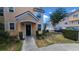 Inviting townhome entrance with a black door, trimmed in white, and a landscaped front yard at 3433 Soho St # 101, Orlando, FL 32835